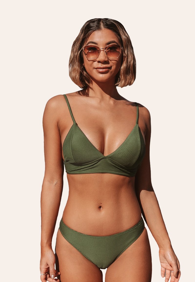 Completo bikini verde oliva, texture a coste, bralette triangolare con spalline sottili, pantaloni a vita alta coordinati, design minimalista.