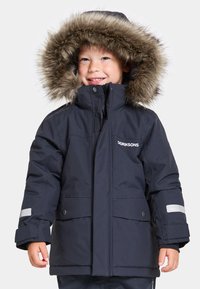 Parka isolée bleu marine avec une capuche doublée en fausse fourrure, fermeture éclair à l'avant, boutons-pression et accents réfléchissants sur les manches. Convient pour les temps froids.
