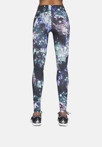 Długie legginsy wykonane z elastycznego materiału, z ciemnym tłem ozdobionym wielokolorowymi wzorami przypominającymi kryształy oraz czarnymi akcentami.