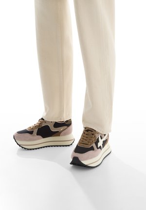 Baskets sportives avec un mélange de dessus en daim noir, beige et marron, semelles texturées et une épaisse plateforme blanche. Design à lacets.