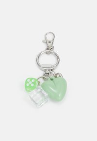 Trousse-clés avec un clip en argent, comportant un cœur vert, un cube transparent et un dé vert avec des points blancs, le tout suspendu à un anneau circulaire.