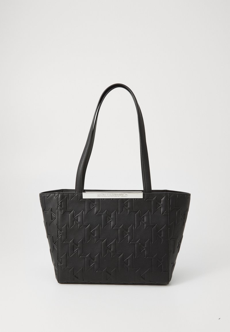 Geantă tote neagră cu o textură modelată, design elegant și două mânere lungi. Prezintă un accent de metal argintiu cu numele mărcii.