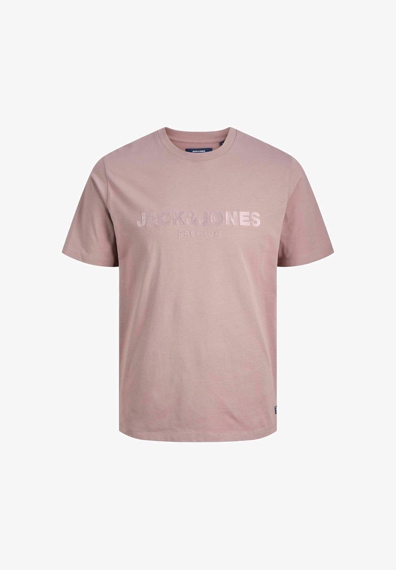 T-shirt en coton rose avec un col rond, des manches courtes et un logo en relief "JACK & JONES PREMIUM" au centre. Texture lisse, coupe décontractée.