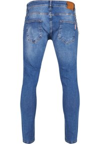 Vékony kék farmernadrág öt zsebbel, látható varrással és bőrpánttal a deréknál. Simma textúra, kopottas megjelenéssel.