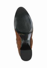 Suela de zapato de ante marrón con una suela de goma. La superficie texturizada presenta un patrón en forma de diamante para un mejor agarre. Logotipo visible cerca del talón.