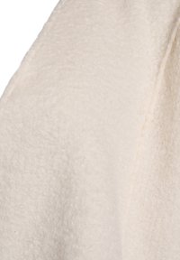 Valge tekstuuriga kangas, millel on pehme ja kohev pind ning sile õmblus serval. Ideaalne mugavaks rõivastuseks või kodutekstiilideks.