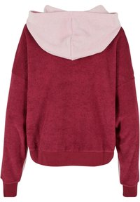Bordeaux hoodie met een zachte roze binnenkap. Heeft een comfortabele pasvorm, geribbelde manchetten en een gestructureerde stof. Geen voorontwerp zichtbaar.