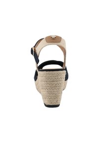 Sandale à semelle compensée en espadrille avec un talon en jute enroulé, tige en tissu bleu marine, bride de cheville en cuir tan et accent de boucle métallique. Talon en fibre naturelle texturée.