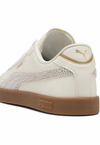 Witte leren sneaker met een gestructureerde grijze suède streep, gouden accenten en een bruine rubberen zool met gegraveerd logo.