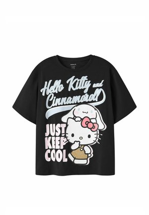 Zwart t-shirt met Hello Kitty- en Cinnamoroll-figuren en de tekst "Just Keep Cool" in wit en pasteltinten gedrukt op de voorkant.