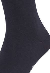 Crna pamučna čarapa s glatkom teksturom, s ojačanim petom i prstima te bijelim logom blizu dna.