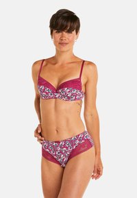 Ensemble lingerie comprenant un soutien-gorge et une culotte dans un profond bordeaux avec un motif floral. Le soutien-gorge est orné de dentelle, possède des bretelles réglables et une finition douce et texturée.