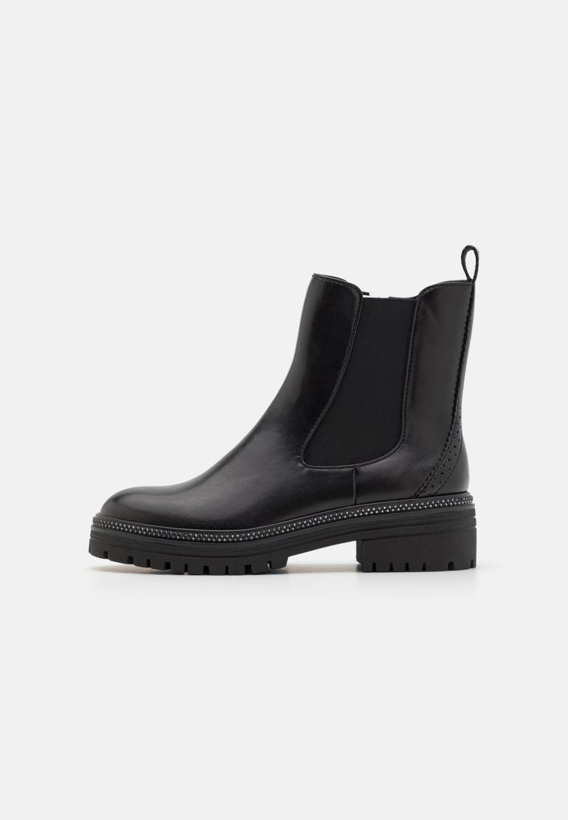 Bottine Chelsea en cuir noir avec panneaux latéraux élastiques, languette à l'arrière, bordure cloutée au-dessus d'une semelle épaisse à crampons, et bout arrondi.