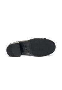 Suela de zapato de goma negra con una superficie texturizada, que presenta un ligero tacón y una área de punta suave. La marca es visible cerca del tacón.