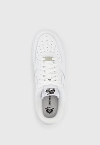 White Nike Air Force 1 sneaker with perforated toe box, laces, Nike logo on tongue, and "EASE" printed on the insole.
