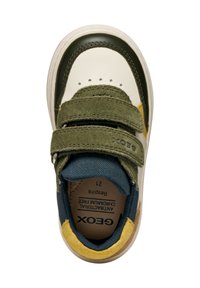 Gröna och krämfärgade sneakers med två kardborreband, mockadetaljer, en texturerad blå insida och gummisula. Modellnamn och storlek är synliga på insidan.