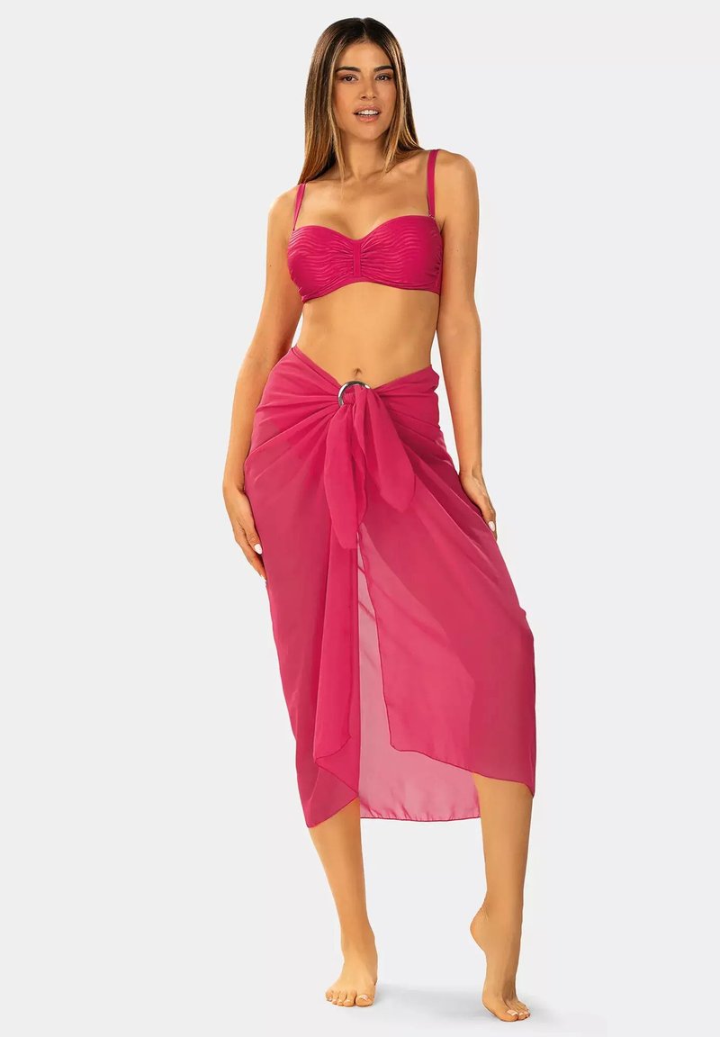 Różowy bikini z teksturowanym topem i pasującą przezroczystą sarongą zawiązaną w talii, z okrągłym akcentem przy węźle.