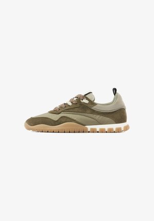 Olive green and beige low-top sneaker with suede and fabric panels, brown patterned laces, pull tab on heel, and tan rubber sole with tread.