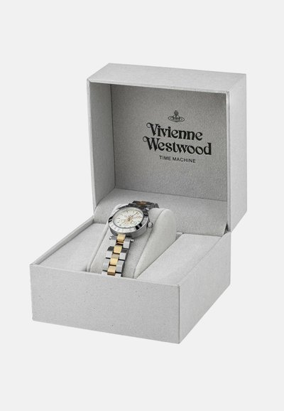 Zilveren en gouden twee-tonen horloge met een ronde witte wijzerplaat, genesteld in een grijze doos met het Vivienne Westwood-logo en een zachte binnenbekleding.