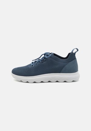 Sneaker in mesh blu con suola bianca leggera. Presenta un upper testurizzato, punta tonda e una linguetta sul tallone per facilitarne l'indossamento.