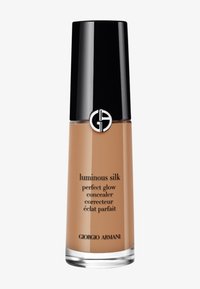 Luminous Silk Perfect Glow Concealer i en klar glassflaske med svart lokk, med sølvlogo og beige produkt inni.