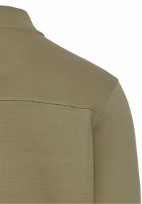 Vue de dos d'une veste beige avec le bas du dos matelassé et le haut du dos et la manche en tissu lisse, équipée d'un col montant.