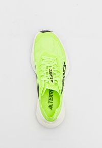 Neon zöld sportcipő hálós felsőrésszel, fekete akcentussal és fehér talppal. Kerek fűzőkkel és texturált talprésszel rendelkezik.