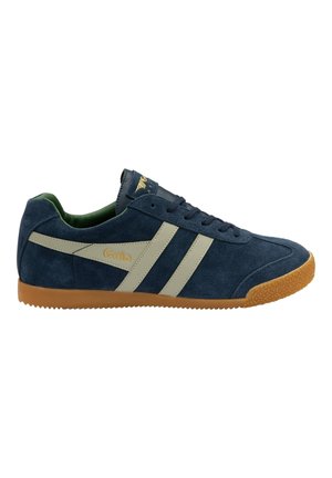 Navy suede sneaker features beige stripes, gum rubber outsole, and green interior lining. Gold logo at tongue adds detail.