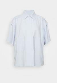 Jasnoniebieska koszula z krótkim rękawem, z kołnierzykiem w kształcie stożka, dwoma przednimi kieszeniami, zapięciem na guziki i luźnym krojem. Wykonana z teksturowanej tkaniny.