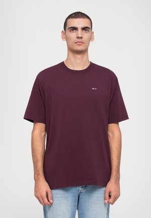 Maroon cotton T-shirt with short sleeves, relaxed fit, round neckline, and small white text logo on the left chest.