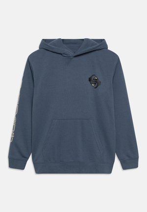 Sweat à capuche bleu avec poche kangourou à l'avant, petit logo géométrique noir sur la poitrine, et texte clair courant le long de la manche droite.