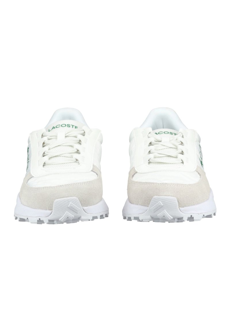 Coppia di sneaker Lacoste bianche e beige con logo verde, viste dalla parte anteriore, che mostrano lacci e suole testurizzate.