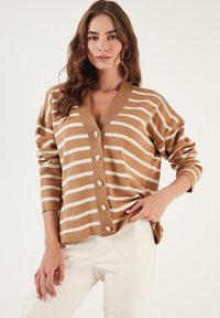Cardigan cu dungi maro și alb, cu decolteu în V, închidere cu nasturi, guler rib, și mâneci lungi. Material moale cu o croială lejeră.