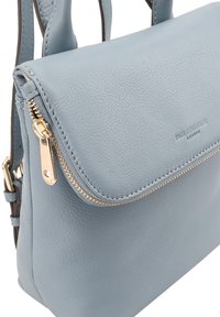 Lichtblauwe leren handtas met een gestructureerd ontwerp, gouden ritssluiting en een textuur. Voorzien van korte handvatten en een verstelbare schouderriem.
