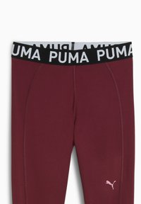 Bordeaux træningsleggings med en sort elastisk talje, der har hvid "PUMA" tekst. Inkluderer et lille pink PUMA-logo på siden.