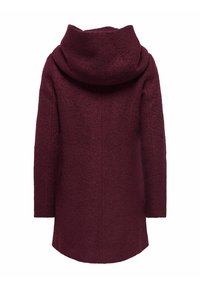 Manteau en laine bordeaux avec un col haut et replié, des manches longues et un ourlet légèrement arrondi, mettant en valeur une surface texturée.