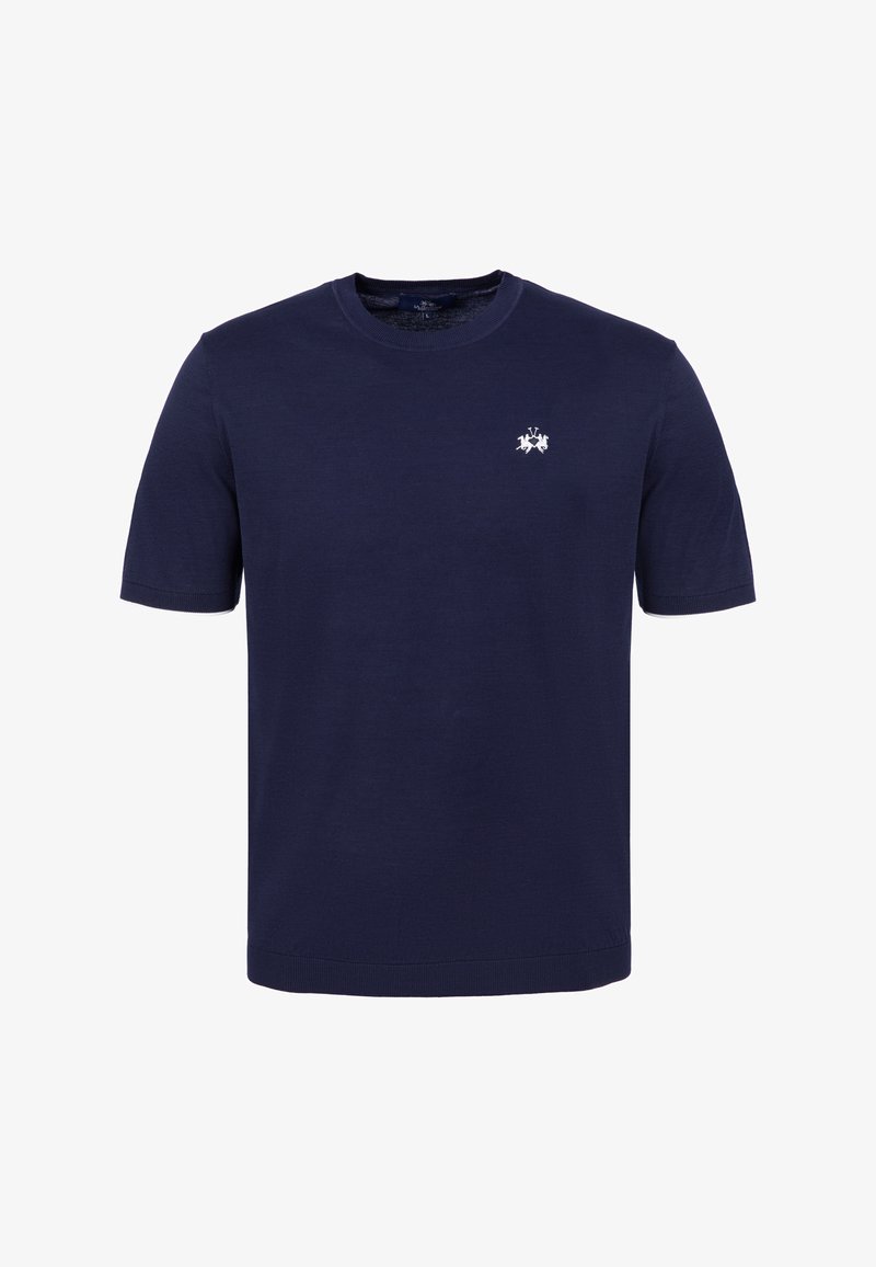 T-shirt bleu marine à manches courtes avec col rond et un petit emblème blanc brodé sur le côté gauche de la poitrine.