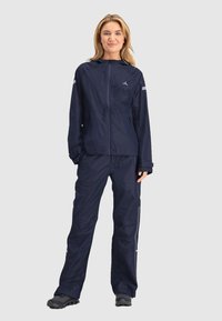 Marinewaterdichte jas met een frontale rits en verstelbare capuchon, gecombineerd met bijpassende broek met reflecterende accenten en een ontspannen pasvorm.