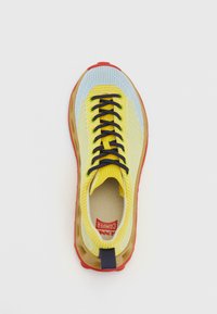 Yellow and blue sneaker with a textured knit upper, black laces, and a red rubber outsole. Features branding on the insole.