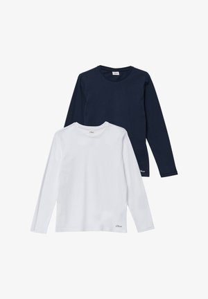 Deux chemises à manches longues : une bleu marine et une blanche. Les deux ont un col rond, un tissu en coton doux et de petits accents de logo près des ourlets.