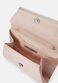 Lyserød satin clutch med en sølvfarvet lås. Har indvendige kortlommer og logo-label. Glat tekstur og enkel design.