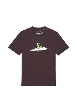 Dark brown t-shirt with a green alien sitting on a white paper airplane surrounded by small stars.