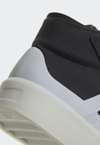 Čierne látkové vysoké tenisky s bielou gumovou podrážkou, štruktúrovanými akcentmi a hladkým dizajnom pätky.