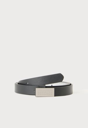 Cintura in pelle nera arrotolata con fibbia rettangolare d'argento che mostra numeri incisi in uno stile minimalista su sfondo semplice.