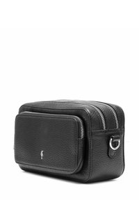 Czarna skórzana torba o teksturowanej powierzchni, podwójne suwaki, przednia kieszeń i metalowy pierścień z boku do mocowania.