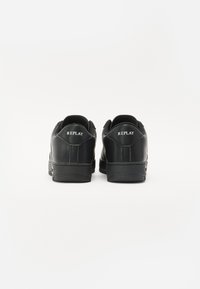 Svarte joggesko med teksturert lærfinish, med gummisåle og hvit "REPLAY" logo på hælen. Enkelt design, lav profil.