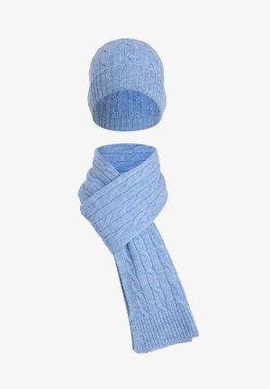 Conjunto de gorro y bufanda de punto en azul claro que presenta un patrón de trenzas, bordes acanalados y textura suave. Ambas piezas son cómodas y a juego.