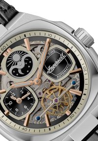 Automatisch horloge met een roestvrijstalen kast, zwarte wijzerplaat, roségouden accenten, dubbele subdials, open mechanische werking en leren band.