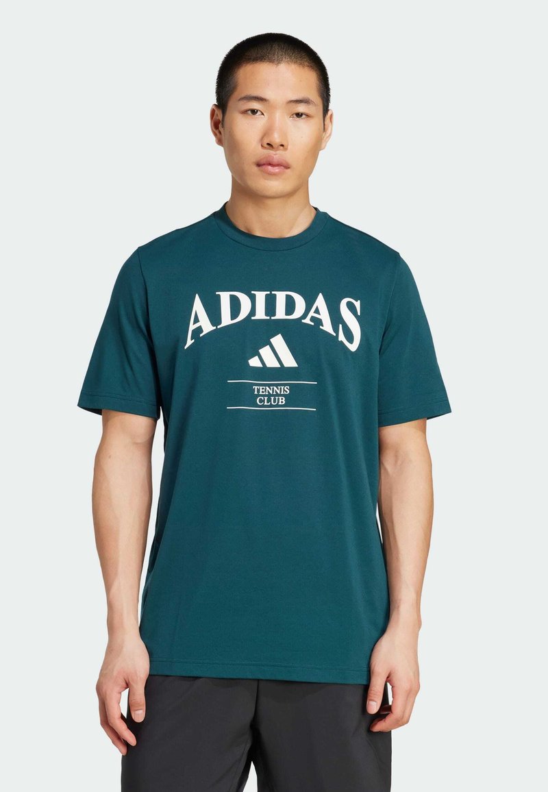 Turkusowa bawełniana koszulka z krótkim rękawem i okrągłym dekoltem, z białym logo "ADIDAS" oraz tekstem "TENNIS CLUB" w wyraźnym wzorze.