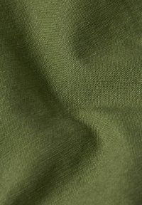 Close-up of textured olive green fabric showing detailed woven fibers and subtle folds.